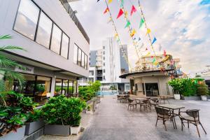 a patio with tables and chairs on a building at Shewin de Bangkok in Ban Bang Bamru
