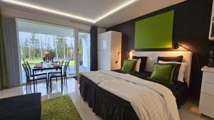 a bedroom with a bed with a table and a green wall at Eco-friendly stay with hot tub & panorama view in Oulu +51 photos