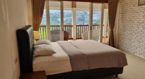 a bedroom with a bed and a balcony at Ncie property in Cangkuang