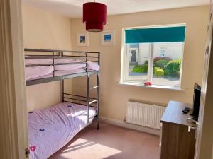 a bedroom with two bunk beds and a window at The Coach House in Par