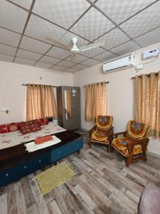 a bedroom with a bed and two chairs at Prime Area 1AC Room Budget Stay in Bhopal