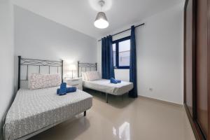 a bedroom with two beds and a window at El Rincon de Famara in Famara