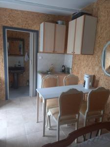 a kitchen with a table and chairs and a table and cabinets at Kassiani House 2 in Neochorópoulon