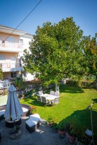 a garden with a table and chairs and a tree at Kassiani House 2 in Neochorópoulon