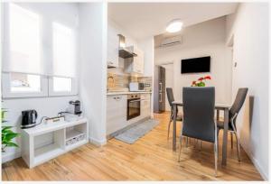 a kitchen and dining room with a table and chairs at Colombo House in Quartu SantʼElena