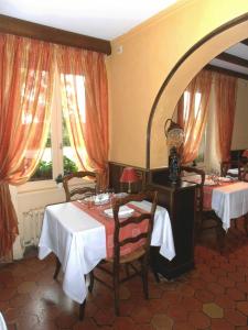 une salle à manger avec deux tables et un miroir dans l'établissement Auberge d'Andaines, à La Ferté-Macé