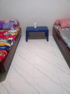 AmbaritaDavid Silalahi的客房设有两张床和一张蓝色的桌子。