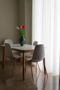 a table with chairs and a vase with flowers on it at Le Manzé in Torremaggiore