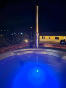 a bath tub at night with a building in the background at Panoramic Chalet Bran in Bran