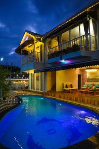 a house with a large swimming pool in front of it at Vista Villa- A Riverside Villa in Alibaug in Mamnoli