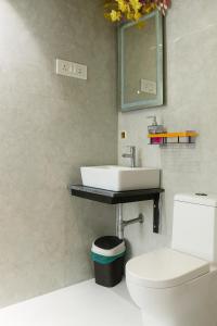 a bathroom with a sink and a toilet at Vista Villa- A Riverside Villa in Alibaug in Mamnoli