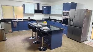 a kitchen with blue cabinets and a island with bar stools at Villa Elysium in Ginetes