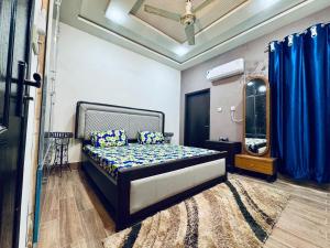 een slaapkamer met een bed en een spiegel bij Gill House in Multan