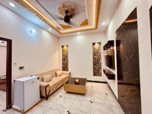 een woonkamer met een bank en een plafond bij Gill House in Multan