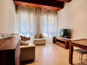 a living room with a couch and a flat screen tv at Casa Baldi | Centro storico di Rimini in Rimini