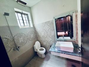 een badkamer met een wastafel, een toilet en een douche bij Gill House in Multan
