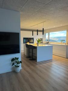 a large kitchen with a table and a large tv at Bright Home with Amazing View in Saltangará
