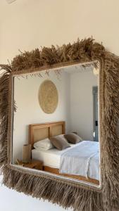 a mirror reflecting a bed in a bedroom at Cozy 2BRs chalet in Einbay Boho designed in Ain Sokhna
