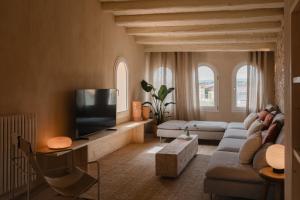 a living room with a couch and a flat screen tv at Casa boutique a Vilamacolum in Vilamacolum