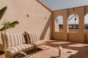 a patio with two chairs and a balcony at Casa boutique a Vilamacolum in Vilamacolum