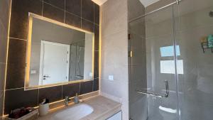a bathroom with a sink and a shower with a mirror at Cozy 2BRs chalet in Einbay Boho designed in Ain Sokhna +34 photos