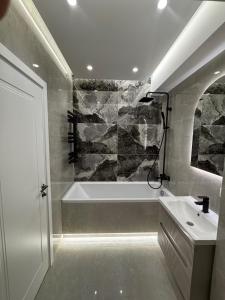 a bathroom with a bath tub and a sink at Stylishapartment in Chişinău