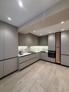 a large kitchen with white cabinets and appliances at Stylishapartment in Chişinău