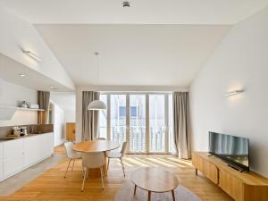 eine Küche und ein Wohnzimmer mit einem Tisch und einem TV in der Unterkunft housingcoruña RUA DO ANXO in A Coruña