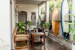 a room with a surfboard and a table and a chair at Sea You Surfers Nest! Hello to waves in a minute walk in Kumbalgama