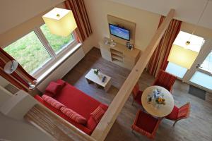 sala de estar con sofá rojo y mesa en Ferienzentrum Trassenmoor, en Trassenheide