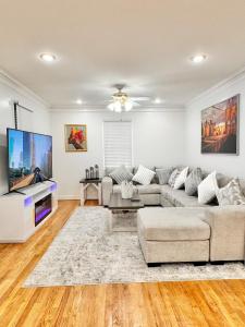 un soggiorno con divano e TV a schermo piatto di DC Getaway Cozy 4BR Oasis by Metro and Airports ad Arlington