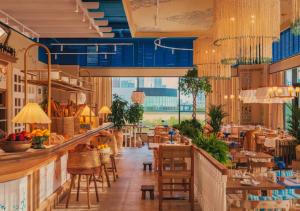 restauracja z niebieskimi sufitami, stołami i krzesłami w obiekcie Апартаменты рядом с Хан-Шатыром, на левом берегу w mieście Astana