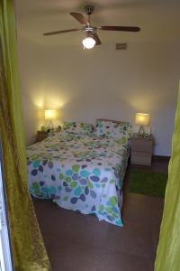 a bedroom with a bed with a blue and green comforter at Casa Jamila in El Alquián
