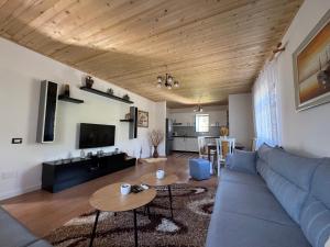 a living room with a blue couch and a table at Vila Curri in Kolgecaj