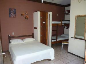 a bedroom with a bed and a bunk bed at Maresias Hostel & Suites in Maresias