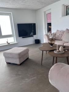 a living room with a couch and a table and a tv at Udsigtsvilla Tambohus in Thyholm