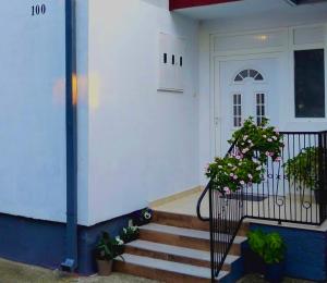 a white house with stairs and a door with flowers at msapartman in Surčin