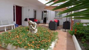 a statue sitting in a garden with flowers at Casa Jamila in El Alquián