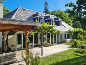 a home with a deck and a house at Tranquil Stylish Home with Nature Pool near Reserve in Somerset West