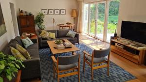 a living room with a couch and a table at Tranquil Stylish Home with Nature Pool near Reserve in Somerset West