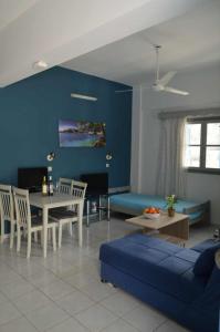 salon z kanapą i niebieską ścianą w obiekcie Valentino's Apartment w mieście Panormos Kalymnos
