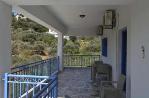 balkon z niebieską balustradą, stołem i krzesłami w obiekcie Valentino's Apartment w mieście Panormos Kalymnos