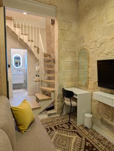 a living room with a desk and a staircase at Sand - Rooftop Views, Wine Cellar & Espresso in Senglea