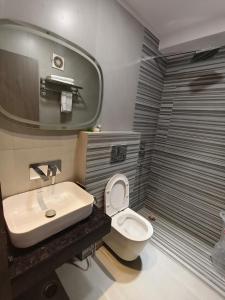 ハリドワールにあるHotel Aryan Innの白いトイレと洗面台のあるバスルーム