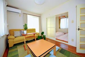 una sala de estar con un sofá y una cama en StayChacha 城下町茶茶1F2F 一棟貸切, en Marugame