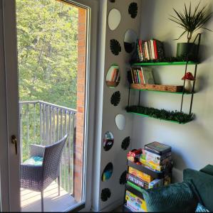 a room with a book shelf and a window at Green Apartament Chill Modlin Airport in Kazuń Nowy