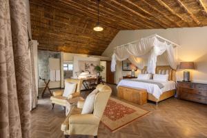a bedroom with a bed and a desk and chairs at Karongwe - Becks Safari Lodge in Hoedspruit +117 photos
