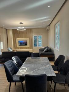 a living room with a table and chairs and a couch at The Lake Villa in Tirana