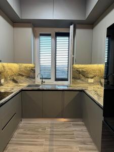 a kitchen with a sink and two windows at The Lake Villa in Tirana +39 photos