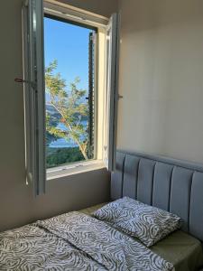 a bed in a room with a window at The Lake Villa in Tirana
